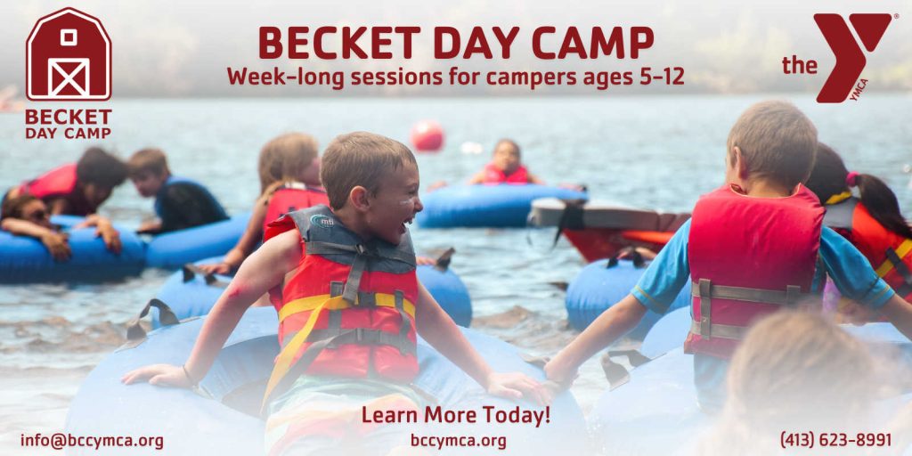 Becket Day Camp: Children wearing life vests tubing and playing in shallow lake water during a summer day camp session.